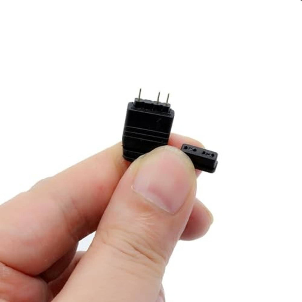 Small black ARGB controller module with exposed header pins, held in hand