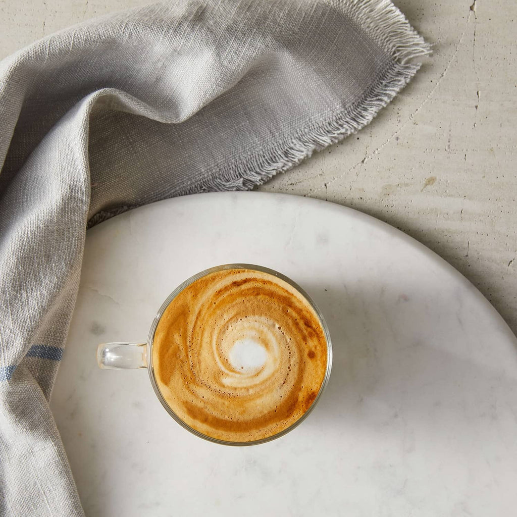 Caramel pecan latte in white cup with latte art and spoon