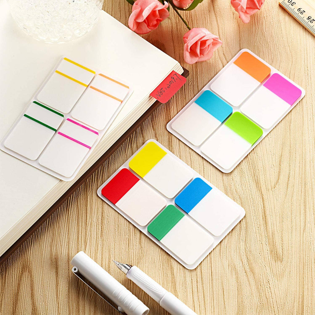 Sticky index tabs in bright colors with white writable label sections on wood
