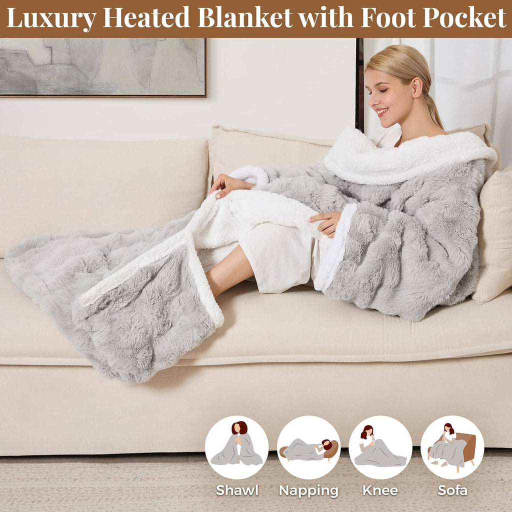 Light gray heated blanket with hood and extended foot pockets, worn over legs on sofa