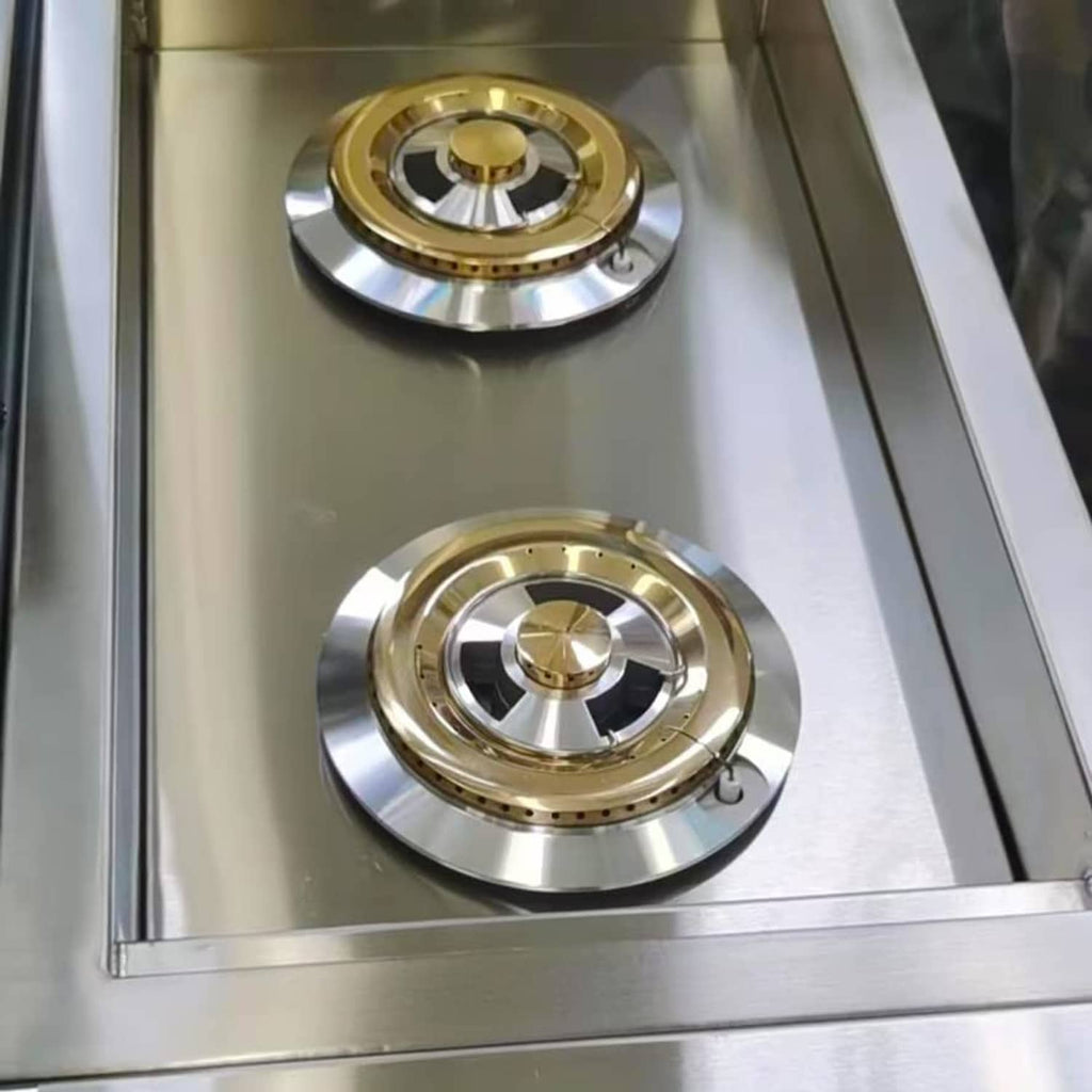 Two brass and silver BBQ side burner heads on a stainless cooktop panel