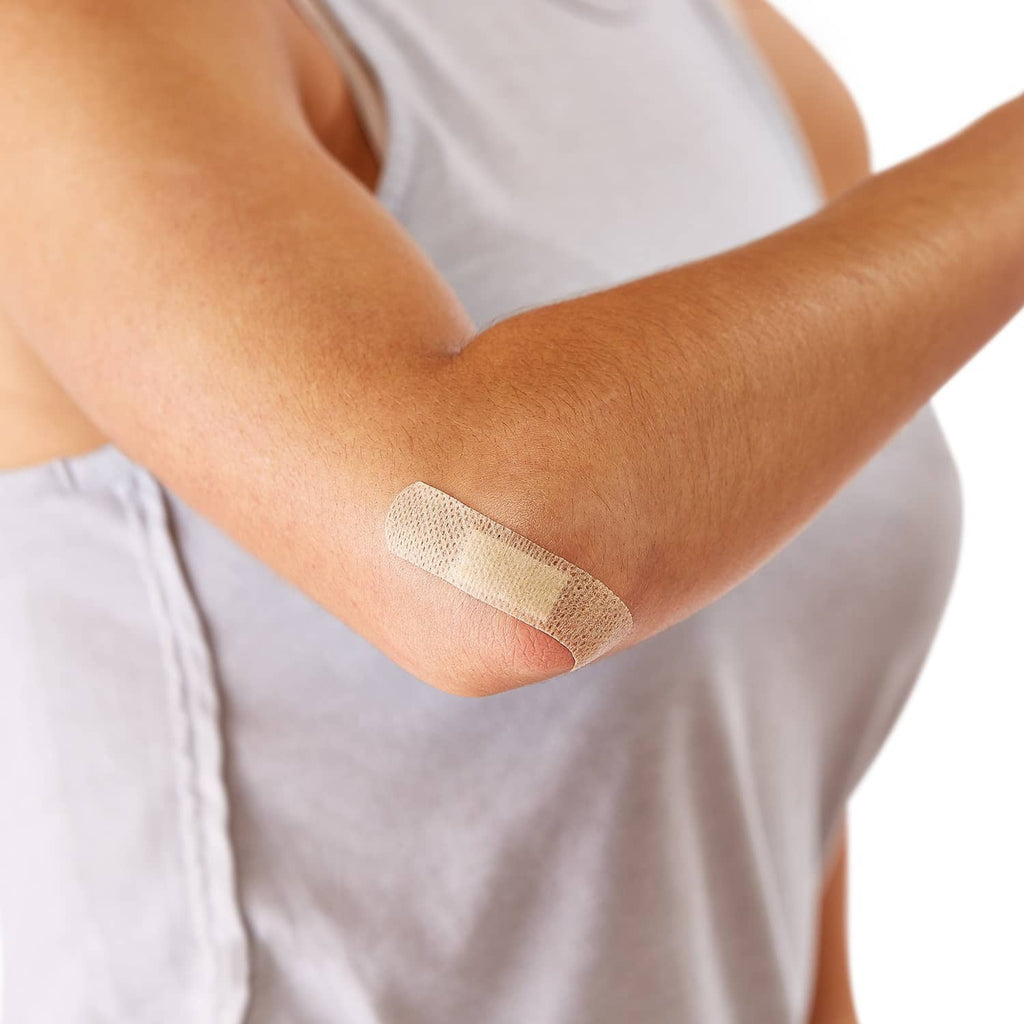 Flex-fabric bandage on forearm, tan strip with white central pad