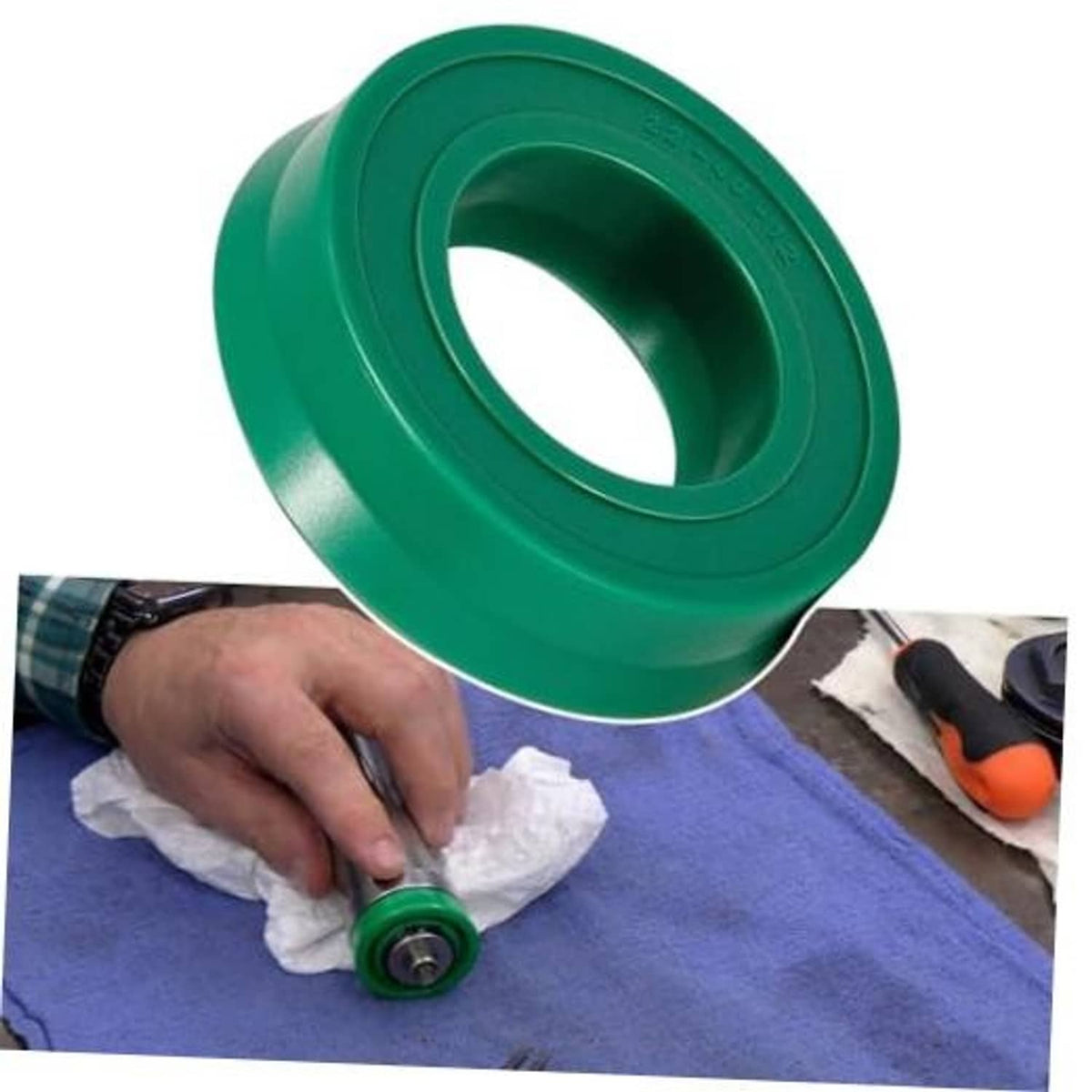 Green U-cup seal being inserted by hand during hydraulic floor jack seal replacement