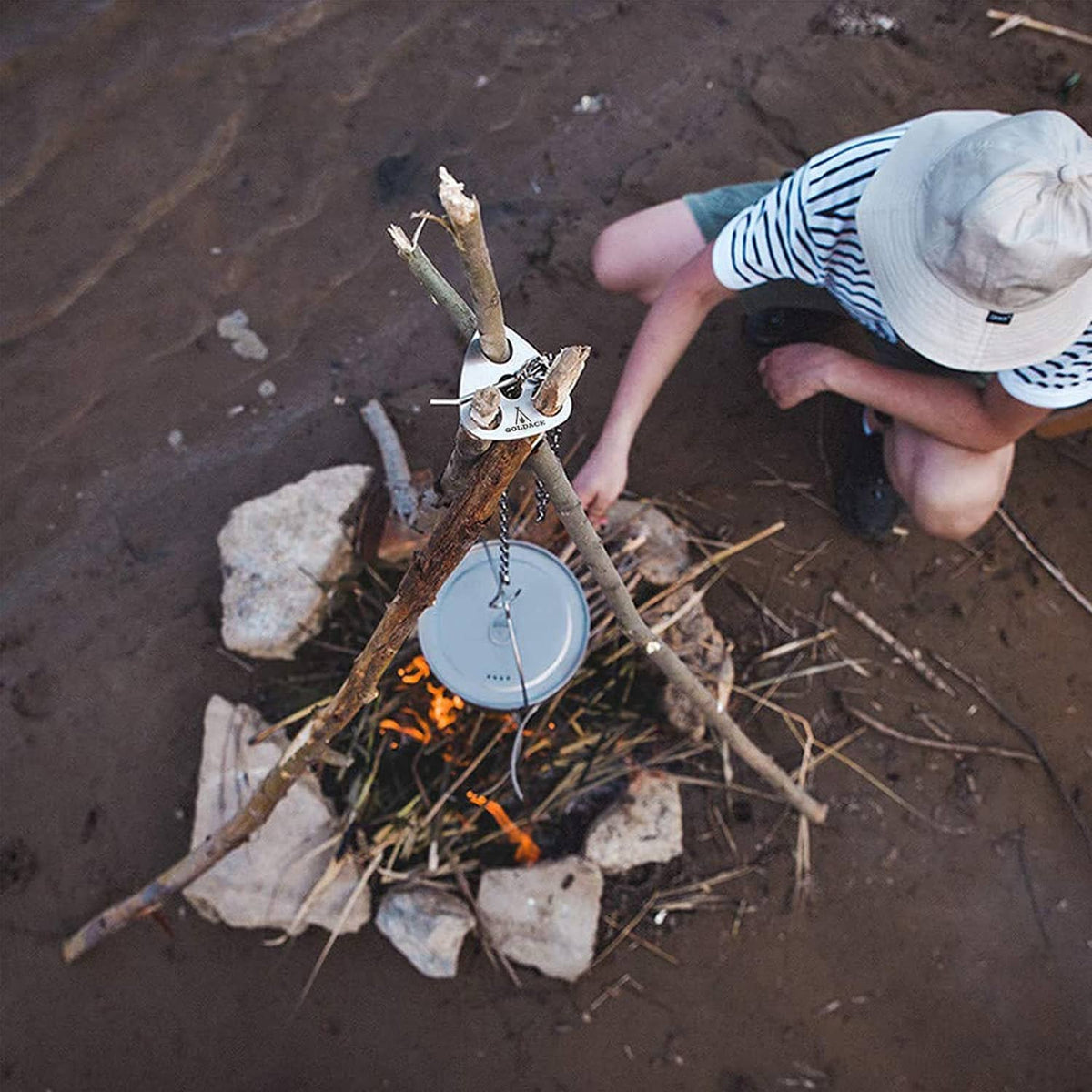 Stainless steel campfire cooking hook set holding a small pan above flames
