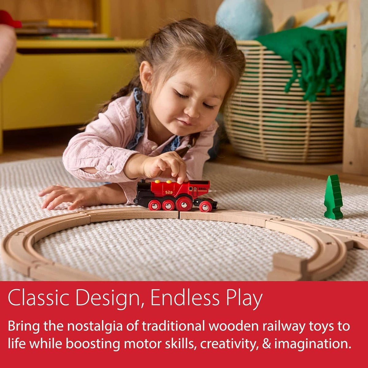 Child playing with red toy locomotive on a wooden railway track
