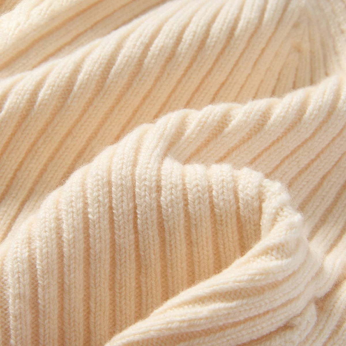 Beige ribbed knit beanie fabric close-up with soft wool texture