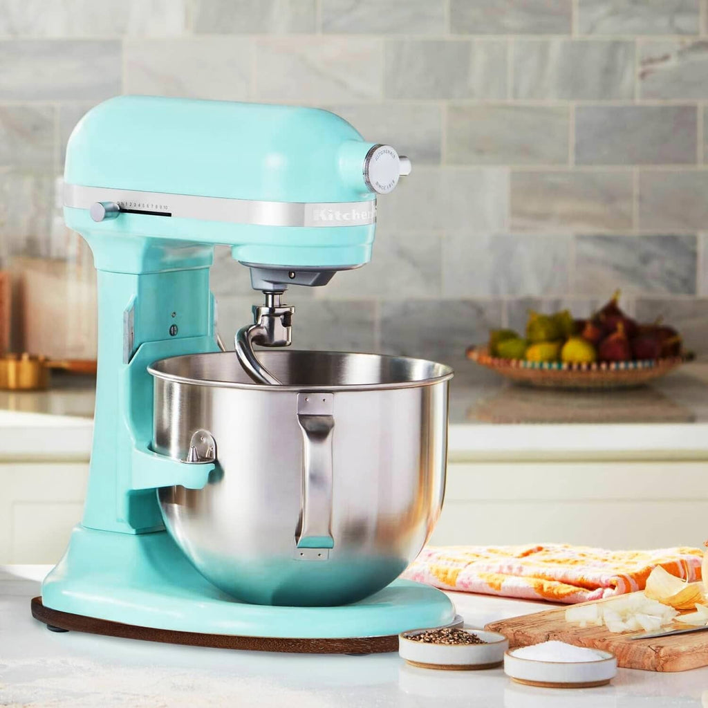 Walnut oval mixer slider mat beside a light teal stand mixer on countertop