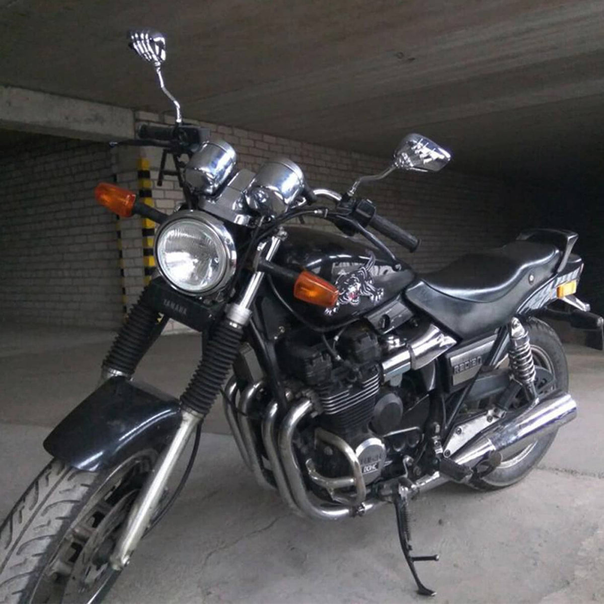 Chrome skull-hand rearview mirrors mounted on a black motorcycle