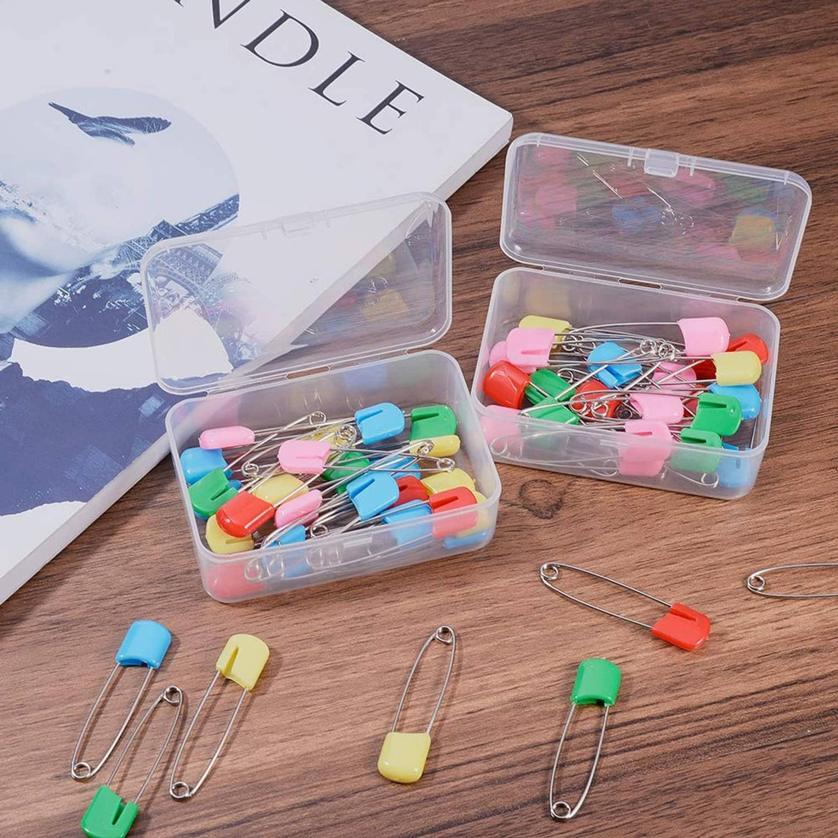 Clear plastic bead storage organizer with compartments, colorful beads and safety pin shapes