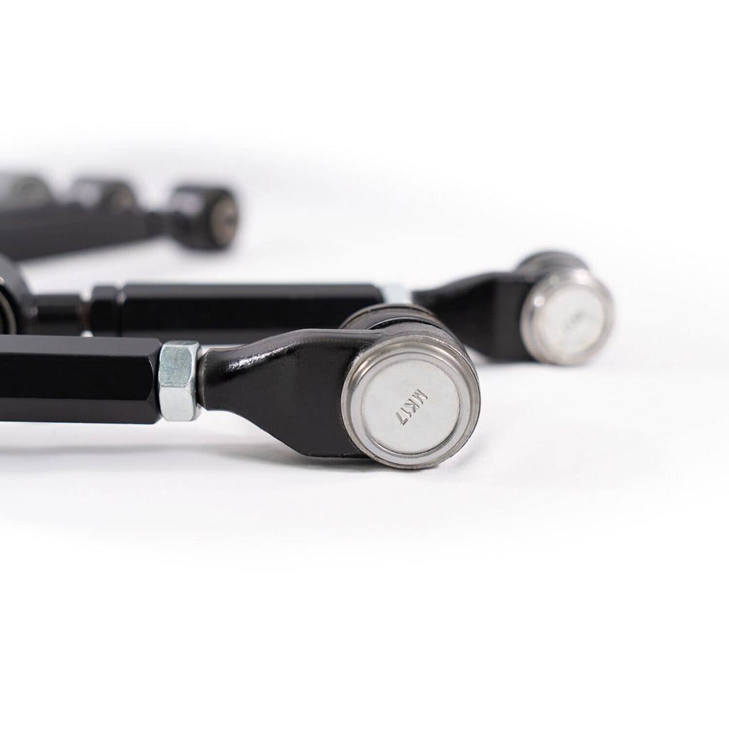 Black control arm with ball-joint end and silver pivot cap, close-up