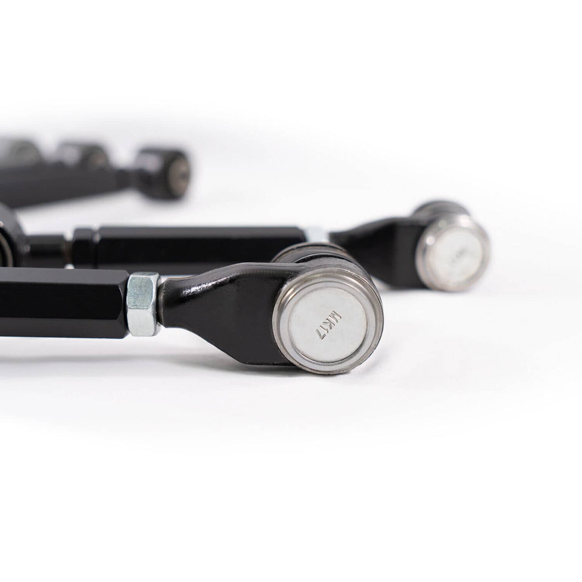 Black control arm with ball-joint end and silver pivot cap, close-up