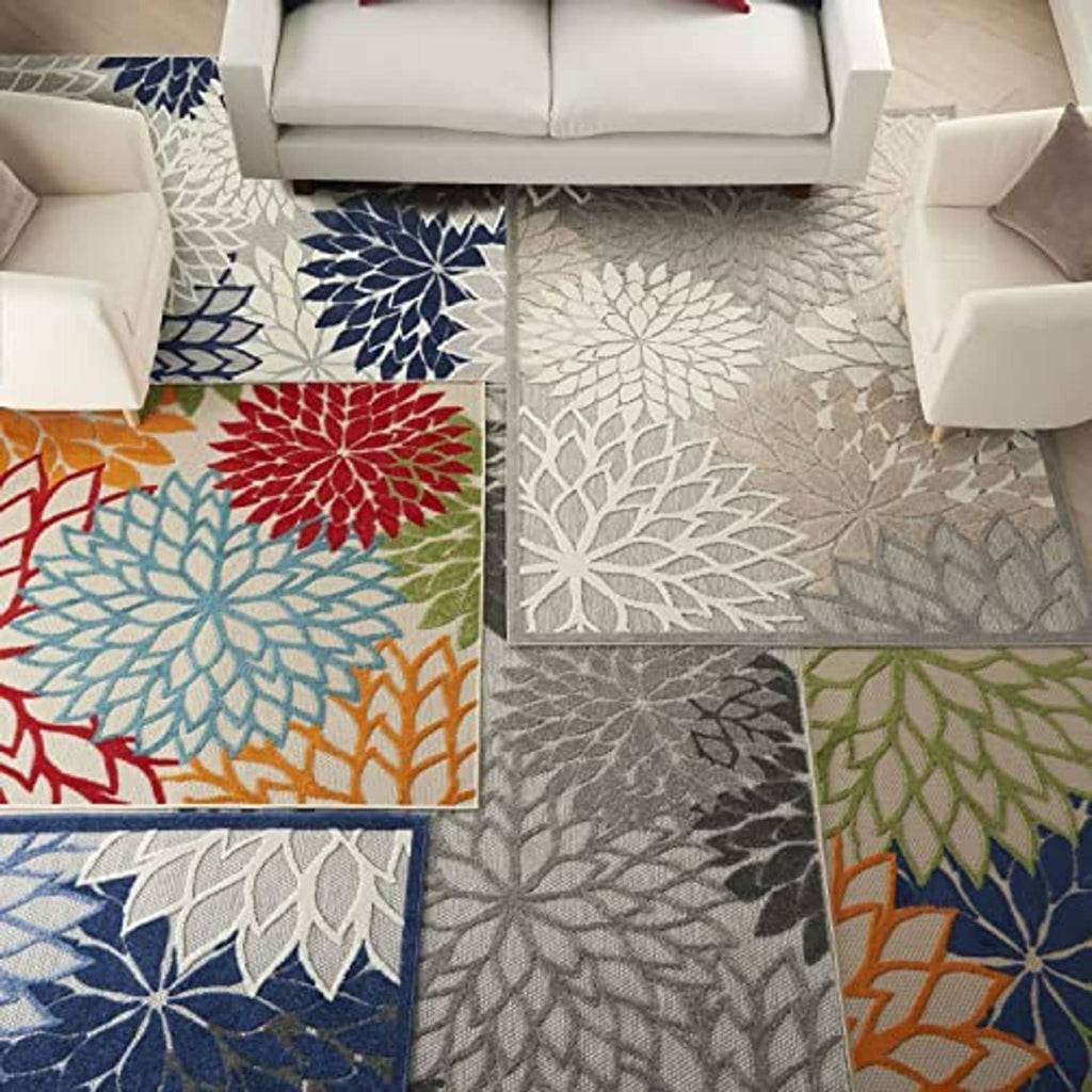 Tropical floral patterned area rug with overlapping leaf-and-flower motifs in light gray