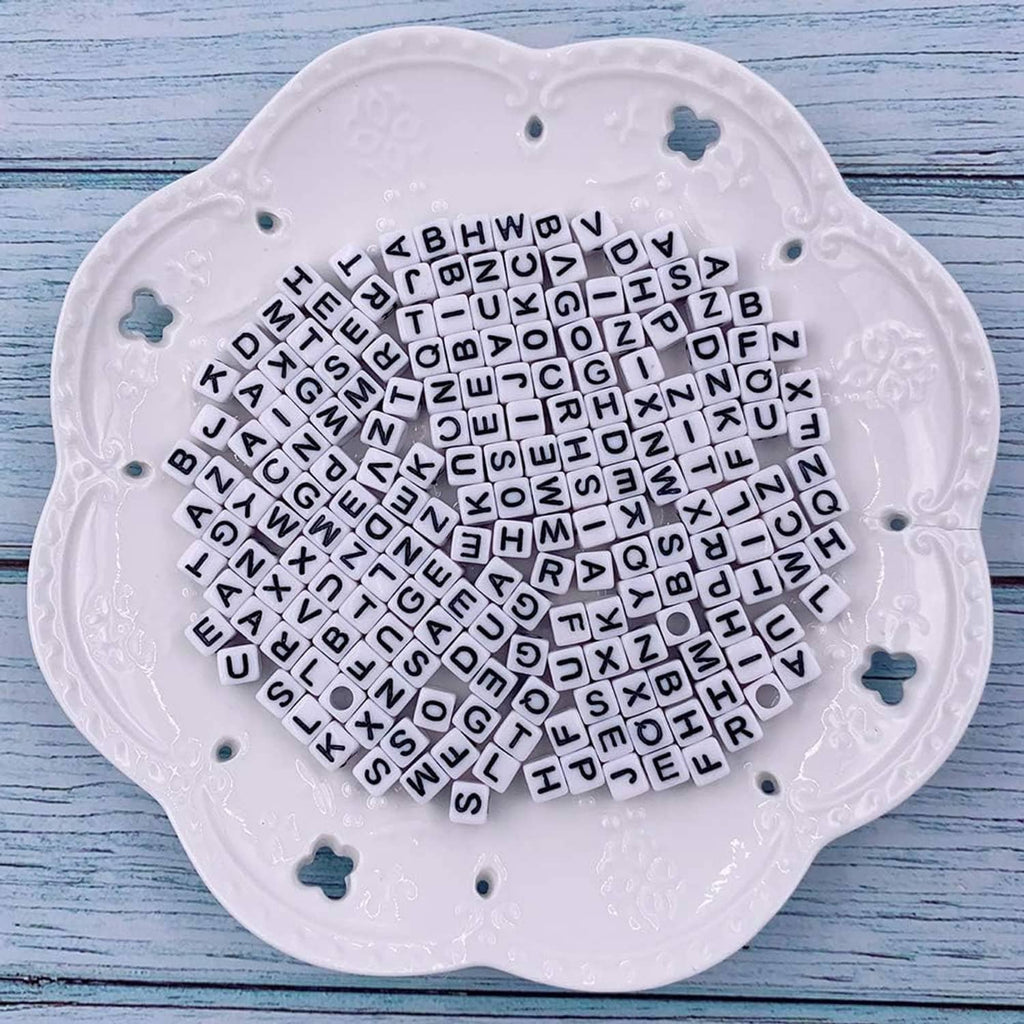 White tray of alphabet letter cube beads, mixed colors