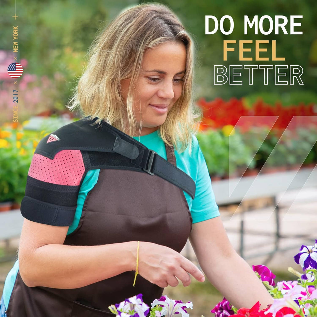 Black and pink shoulder brace with broad support strap across the upper arm