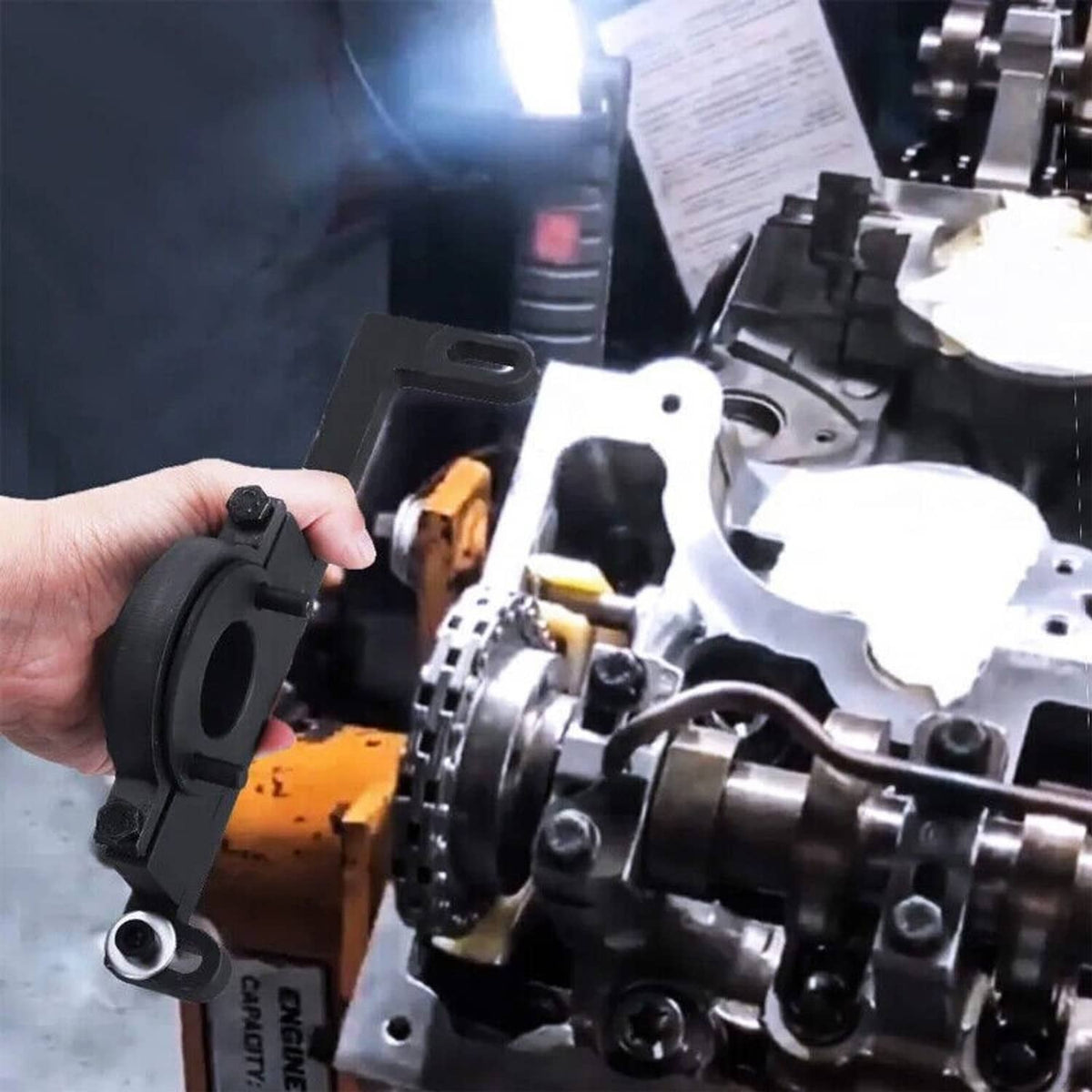 Camshaft timing tool installation near engine timing components, held by hand