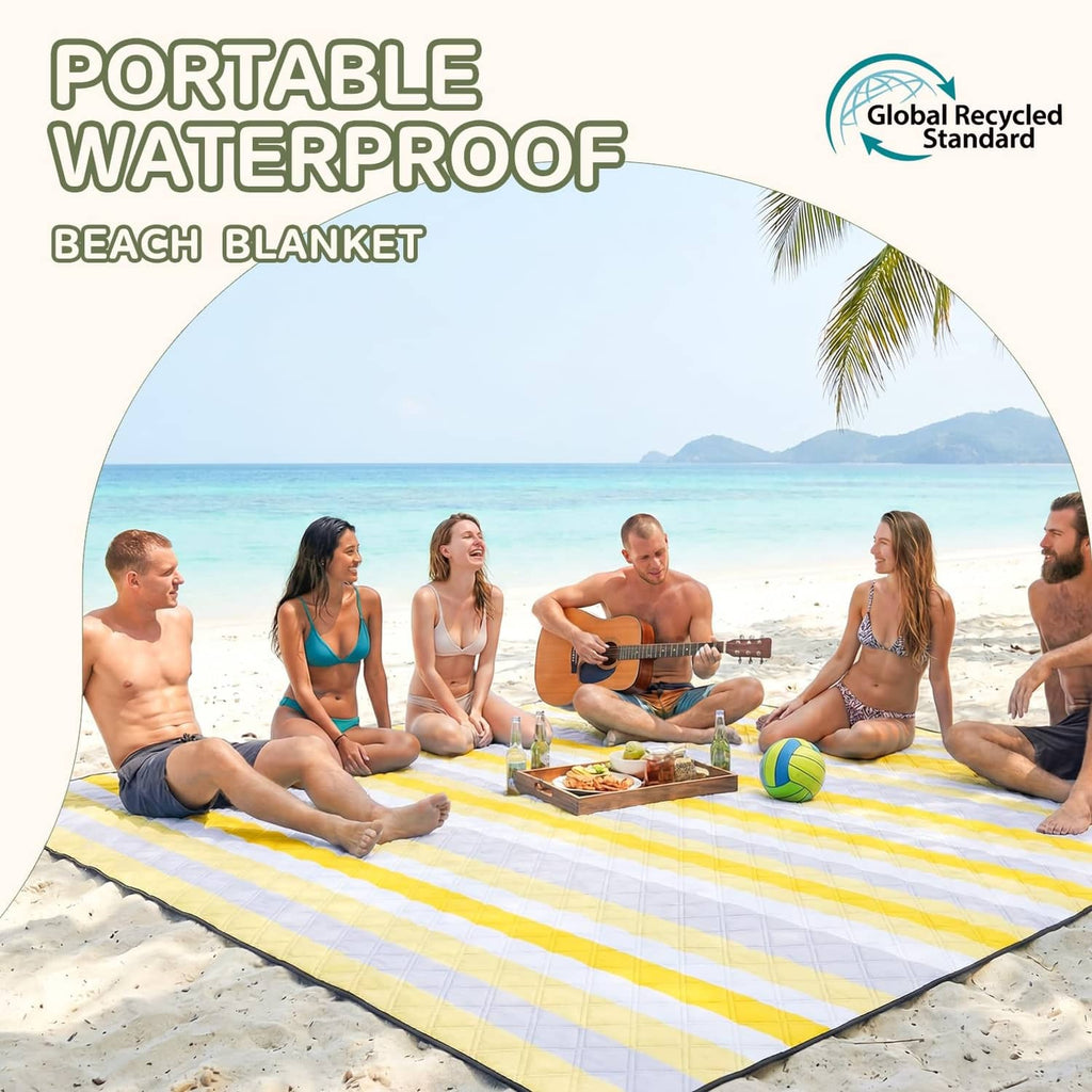 Yellow and white striped waterproof beach blanket with black border on sand