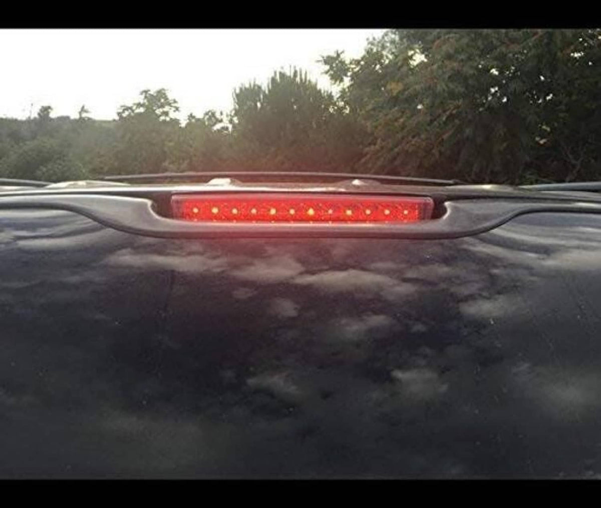 Red LED third brake light bar lit on rear of a dark vehicle