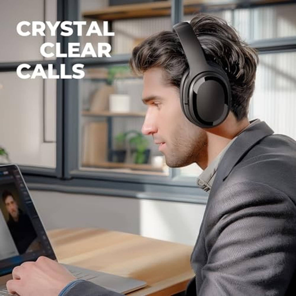 Black over-ear wireless headphones on a person working at a desk