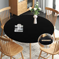 Black round fitted waterproof table cloth, draped on a dining table