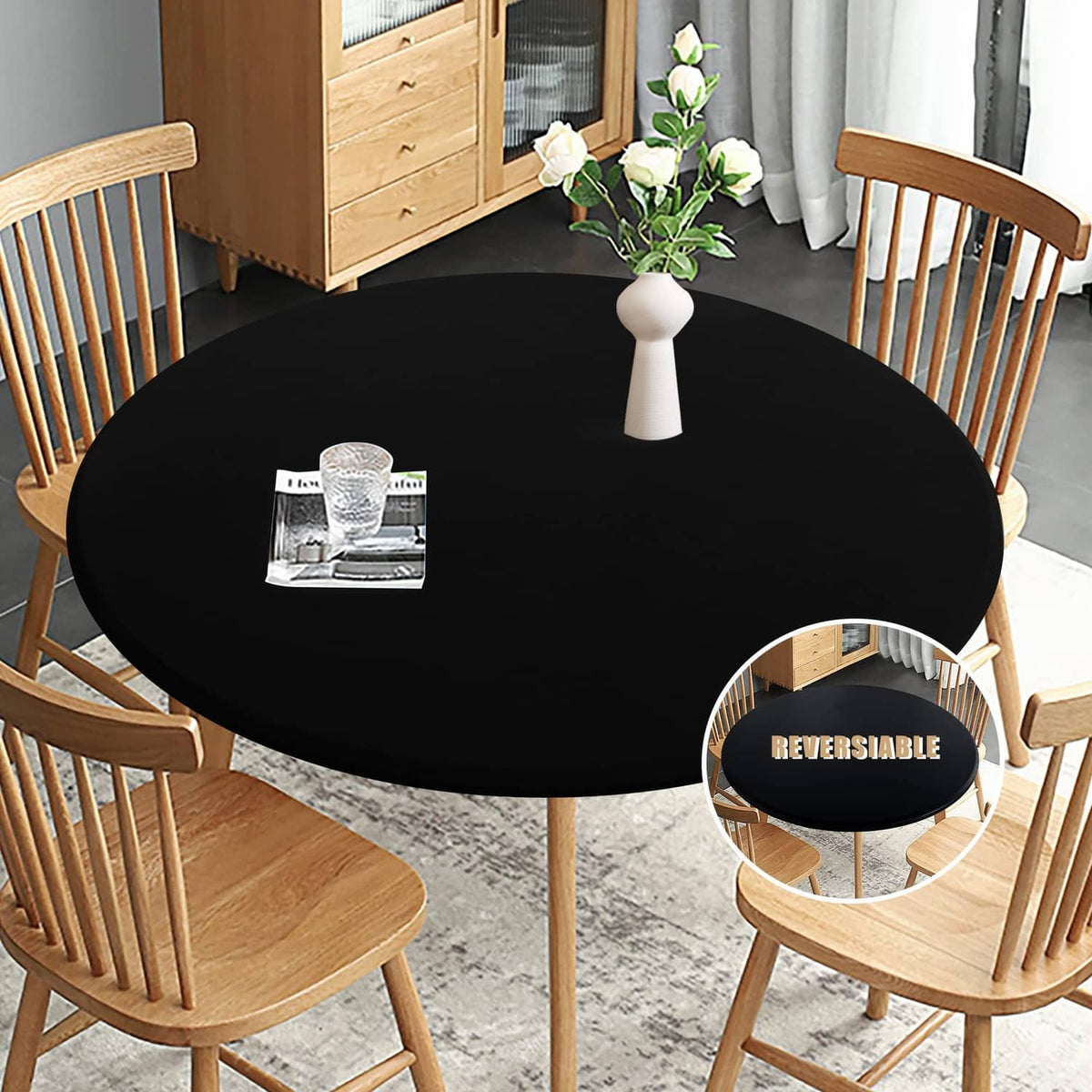 Black round fitted waterproof table cloth, draped on a dining table