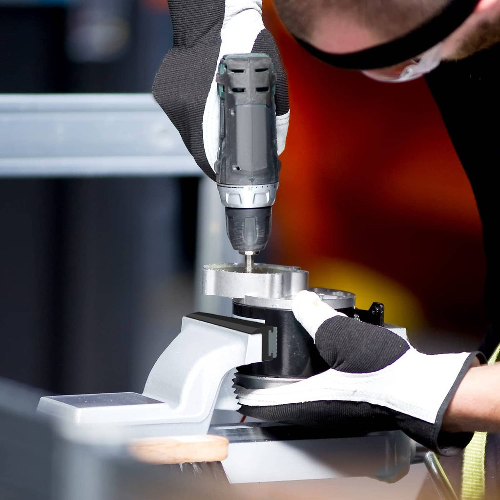 Vice with soft jaw pad inserts holding a metal part while drilling