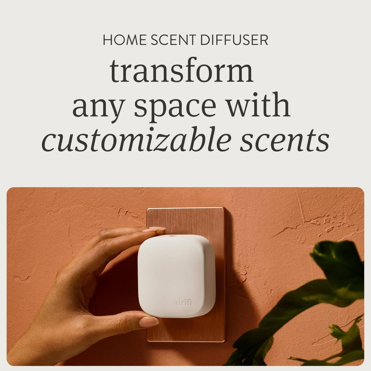 White plug-in scent diffuser on wall outlet, held with fingers for adjustment