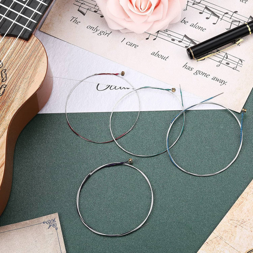 Assorted violin strings with gold end caps and colored windings on music notes paper