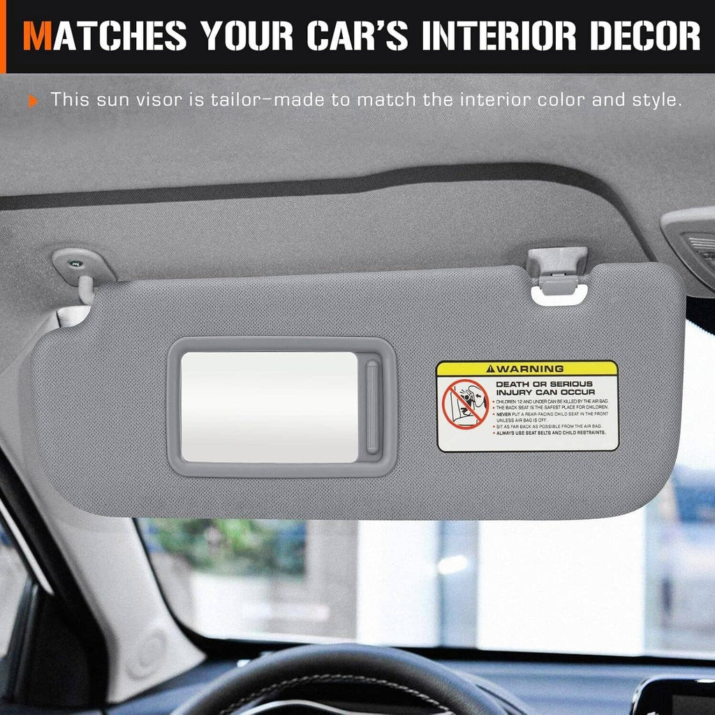 Gray sun visor with rectangular mirror window and warning label, mounted in car interior