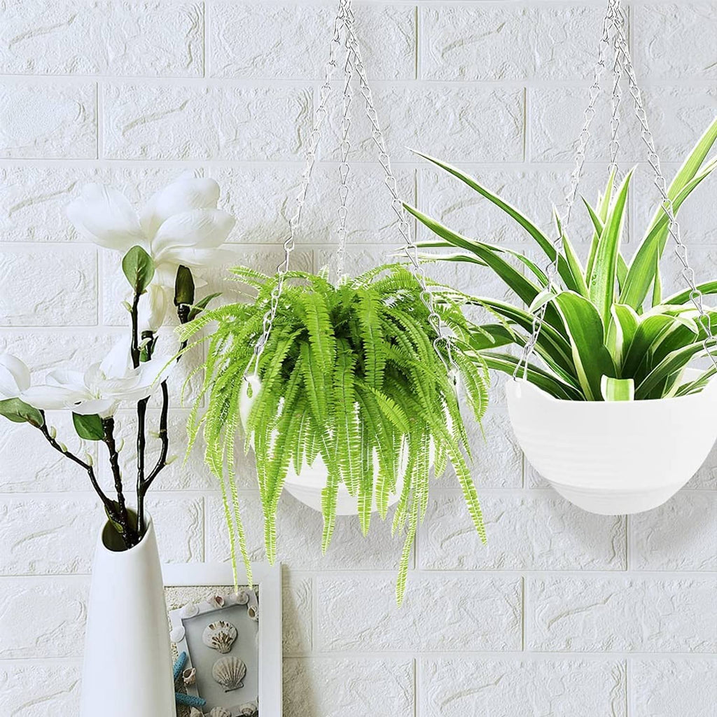 White hanging planter with metal chain and hook holding green plants