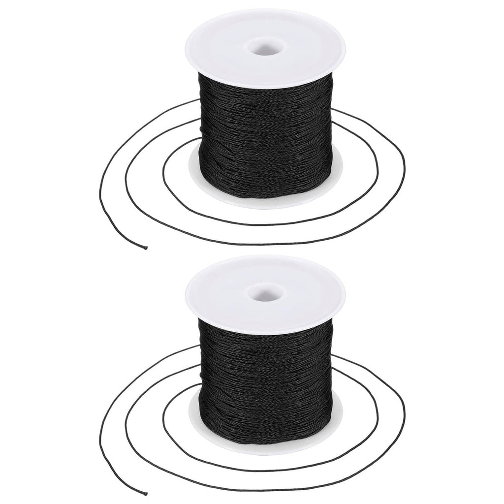 Black 0.6mm nylon string on two white spools for bracelet making
