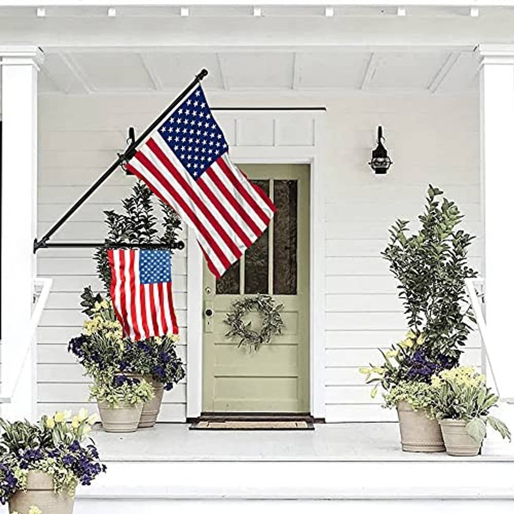 Black wall-mount flagpole bracket with angled pole and rotating finial for US flag