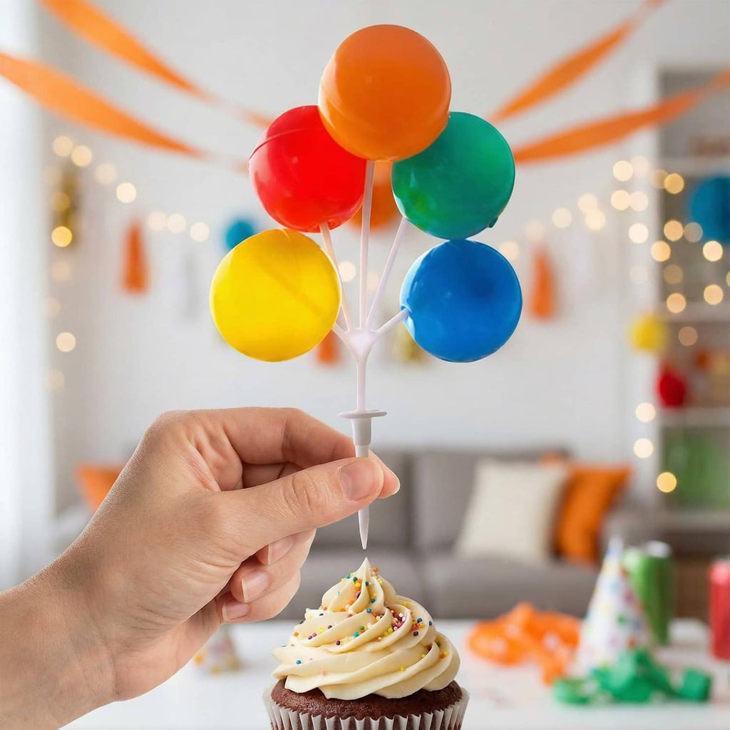 Balloon cake topper on a white stem with orange, red, green, yellow, and blue balloons