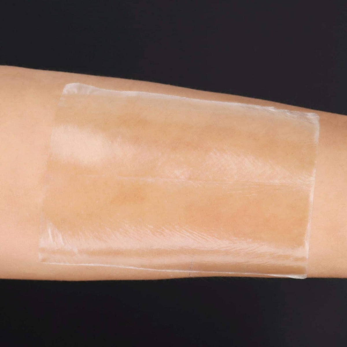 Beige underarm sweat pad adhesive stuck to skin, thin transparent protection layer