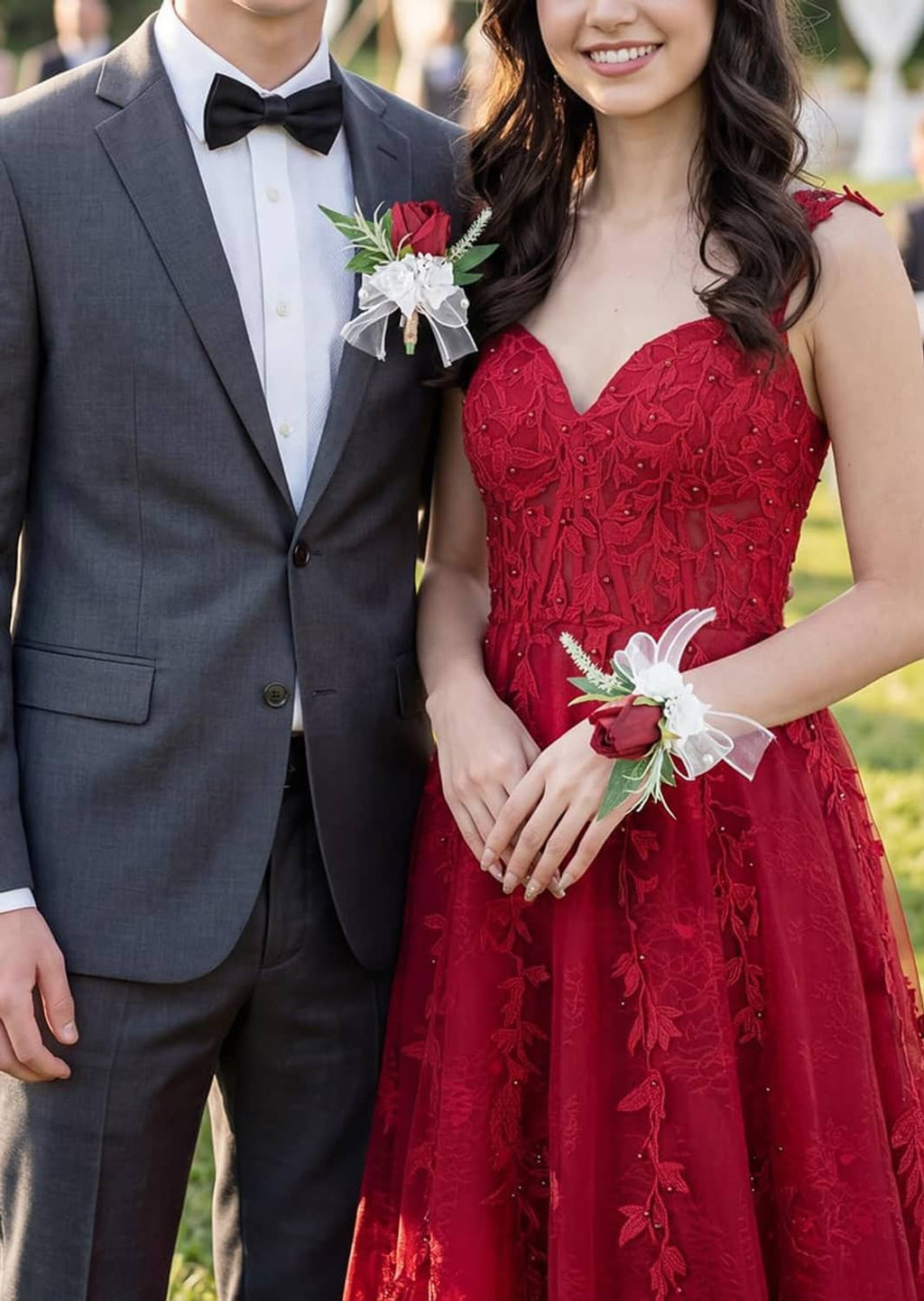 Corsage and boutonniere worn by couple: burgundy rose with white bow, pearls, green leaves