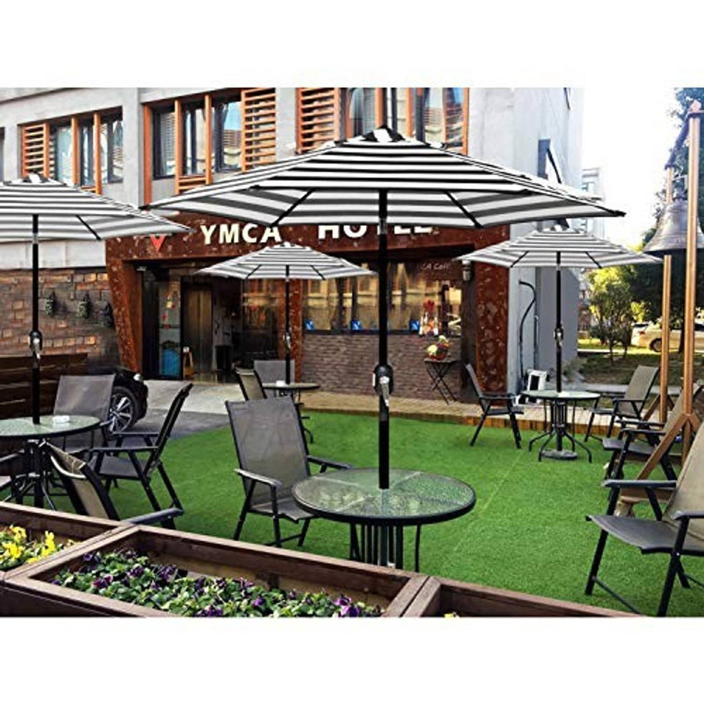 Black-and-white striped patio umbrella open over an outdoor seating area