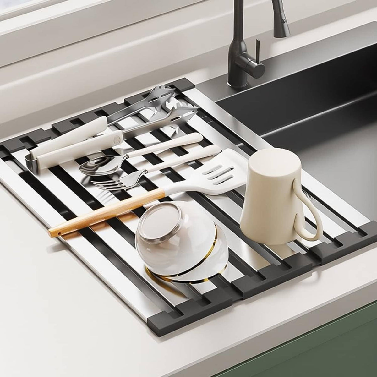 Dish drying rack in sink with utensils and cups on silver slats and black frame