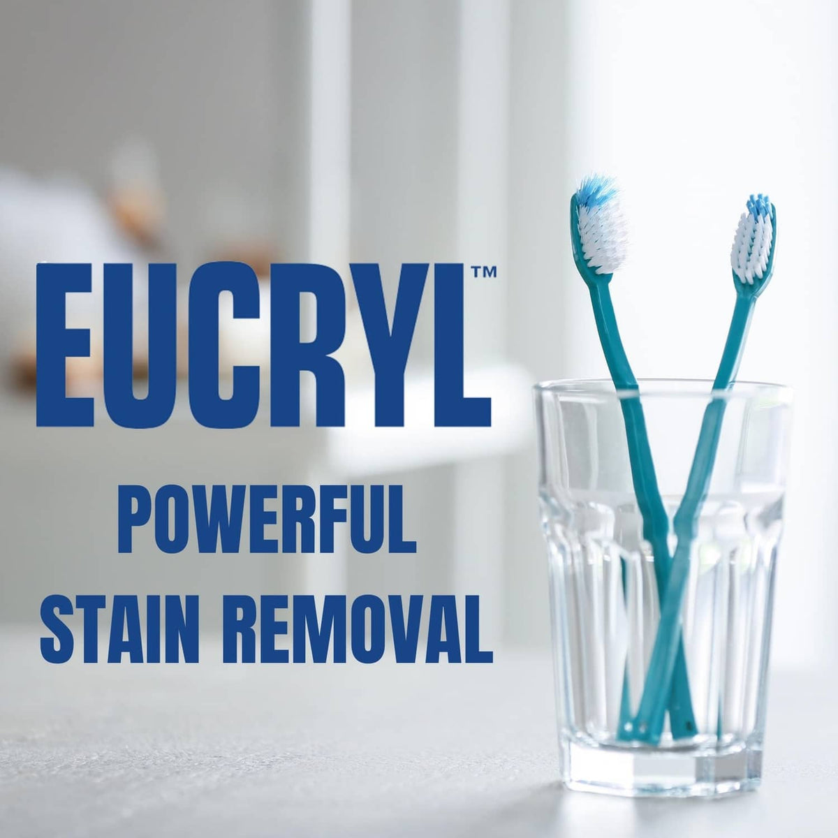 Eucryl toothpowder with blue toothbrushes in a clear cup