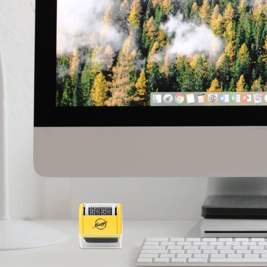 Yellow roller stamp on a desk tabletop, with black ink strip beside it