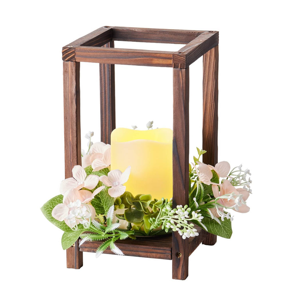 Brown wooden lantern with LED candle and champagne floral wreath, close-up view