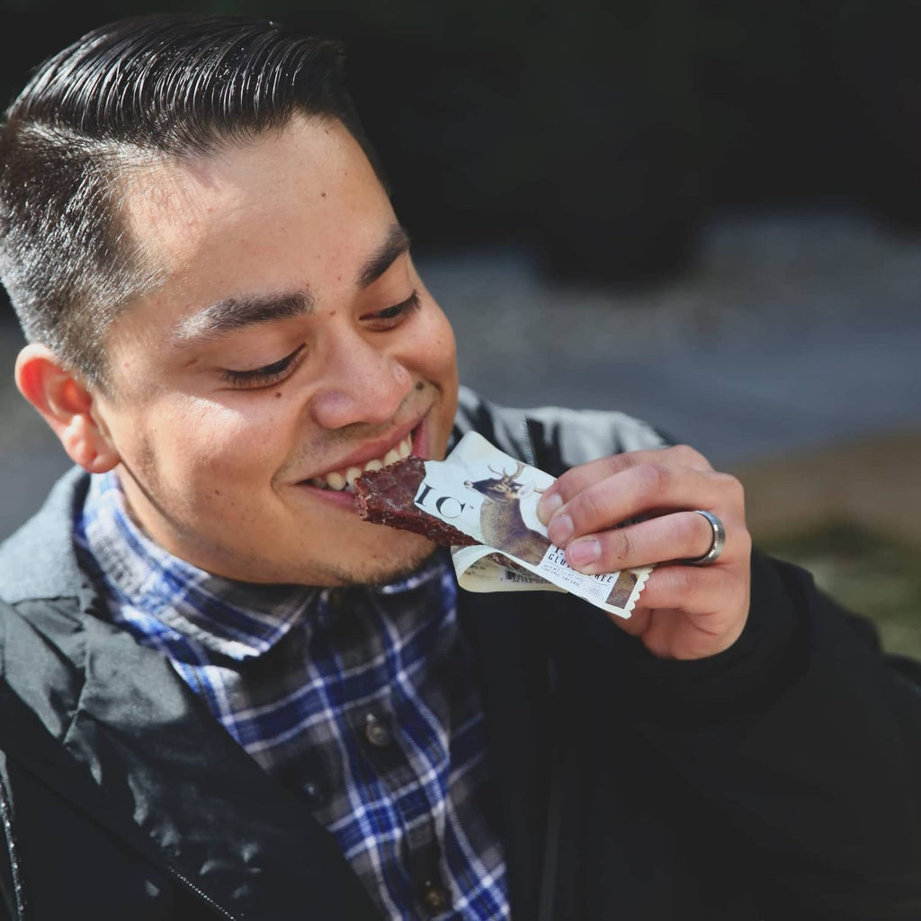 Man eating an Epic Venison Sea Salt + Pepper Bar from a snack packet