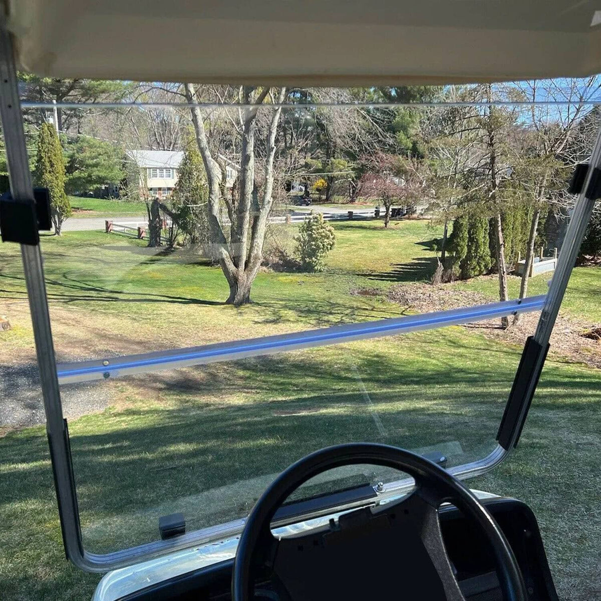 Clear windshield screen on golf cart with metal posts and black bracket mounts