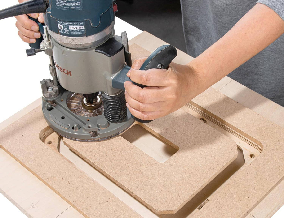 Router bit installed over MDF router table opening using the insert plate template