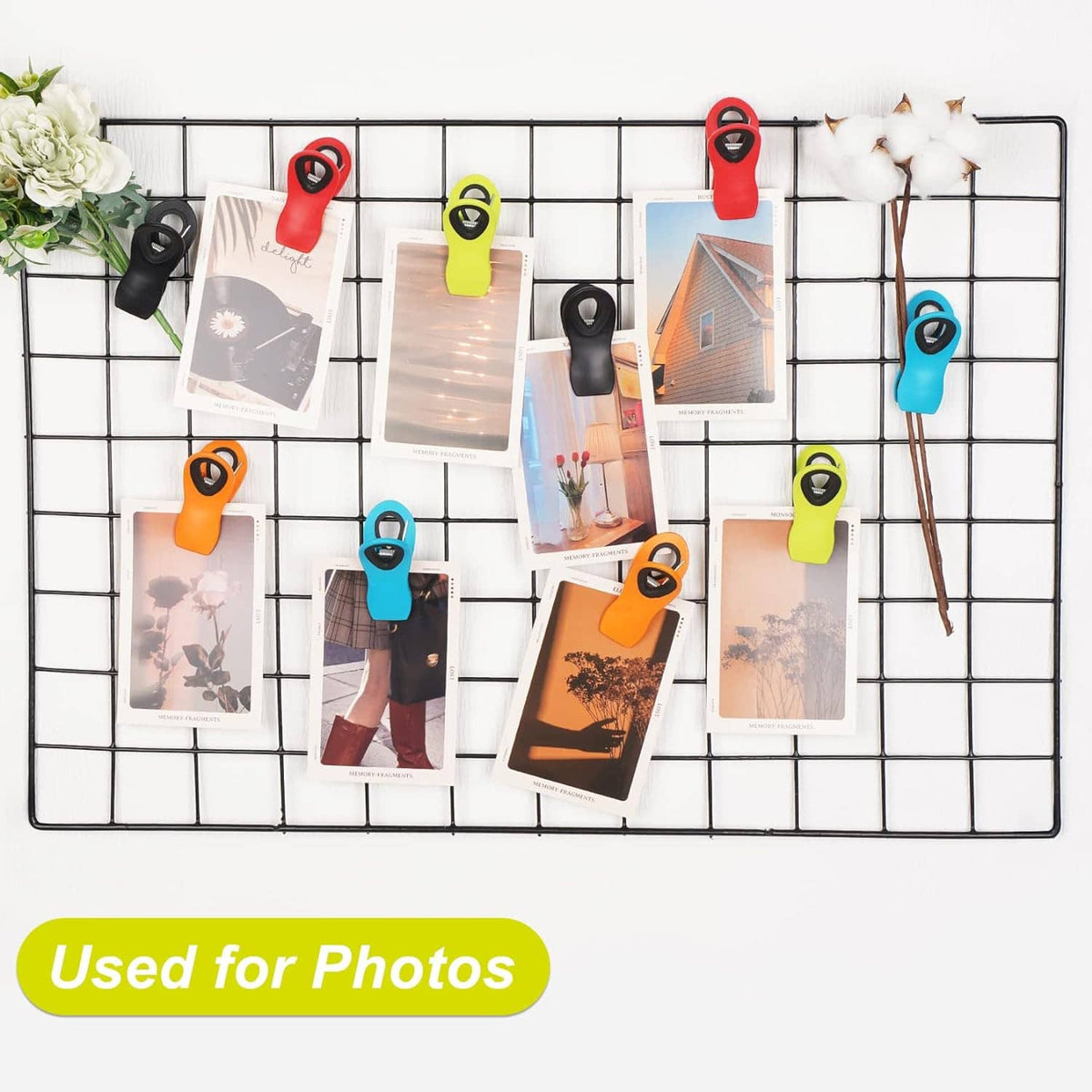 Colorful magnetic clips attached to a grid board holding printed photos