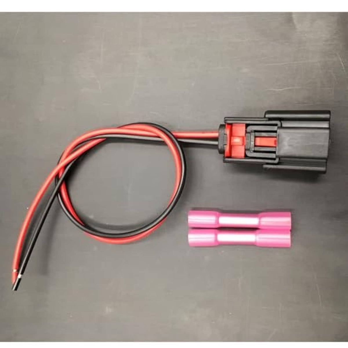 Fog light wiring harness with black connector, red/black cable loop, and two pink terminal sleeves