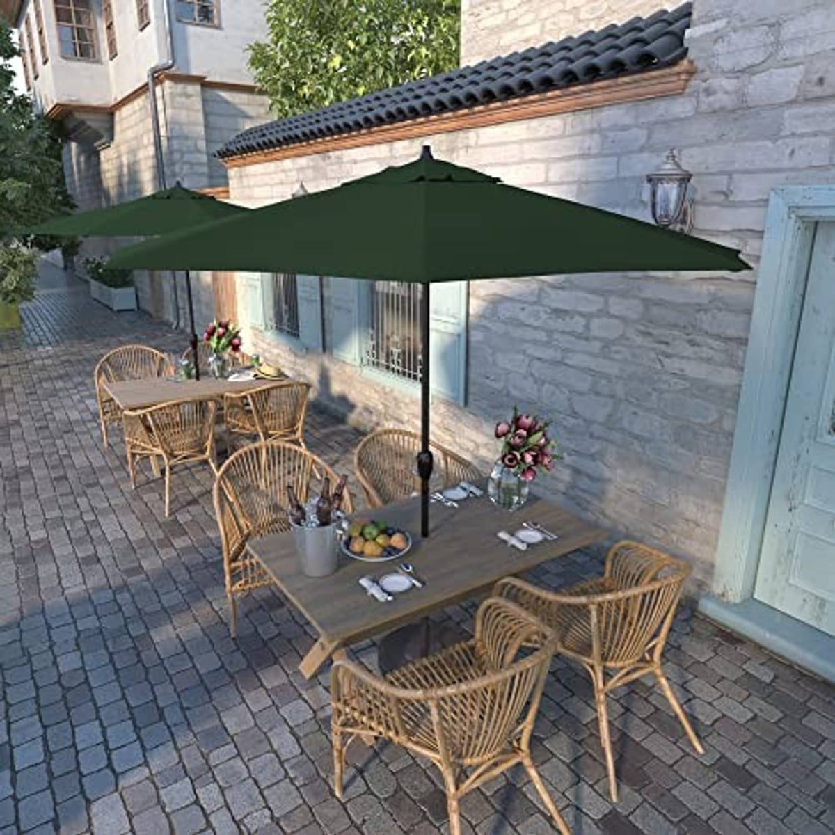 Forest green outdoor patio umbrella shading a table and chairs