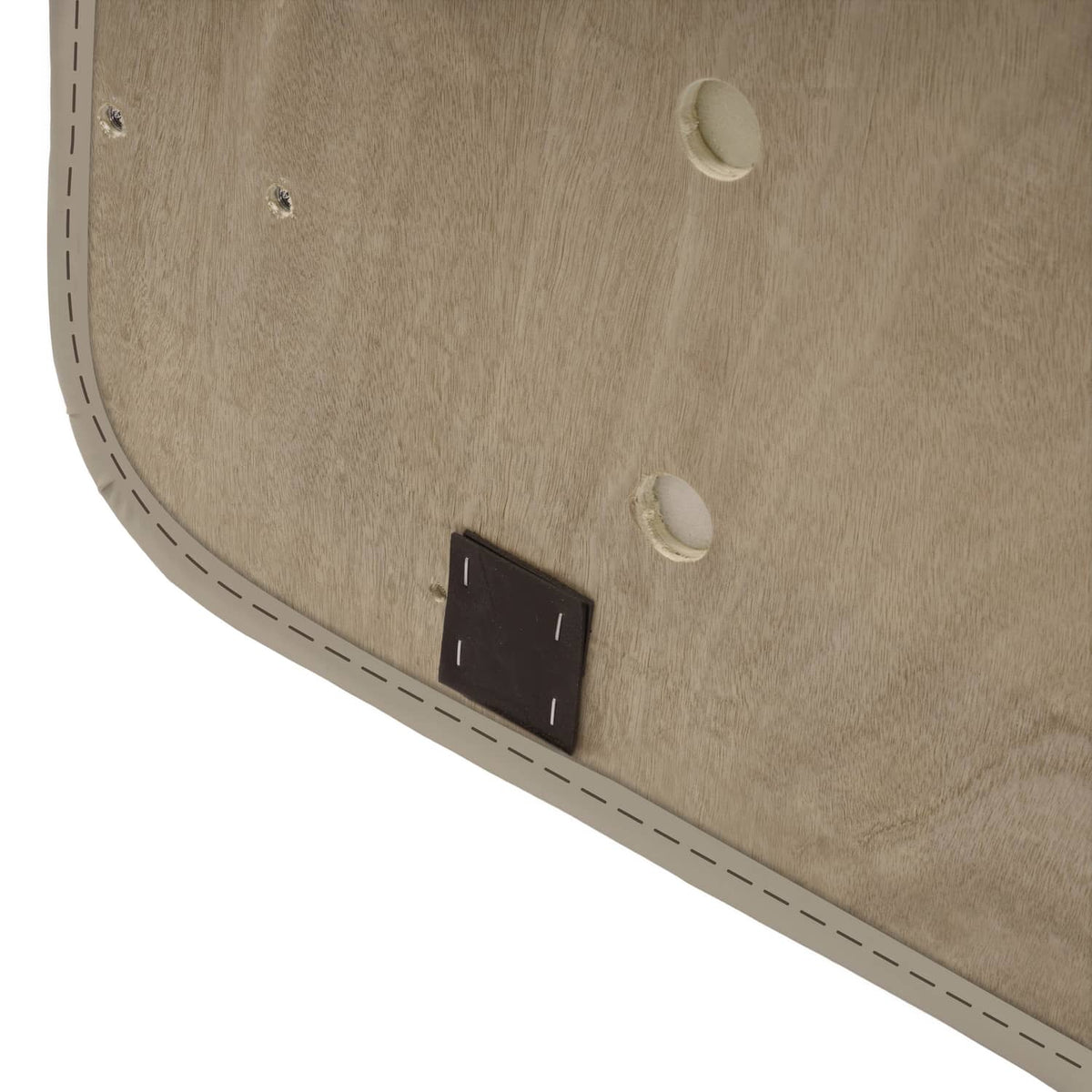 Beige cushion base close-up with black rectangular fastener and mounting holes