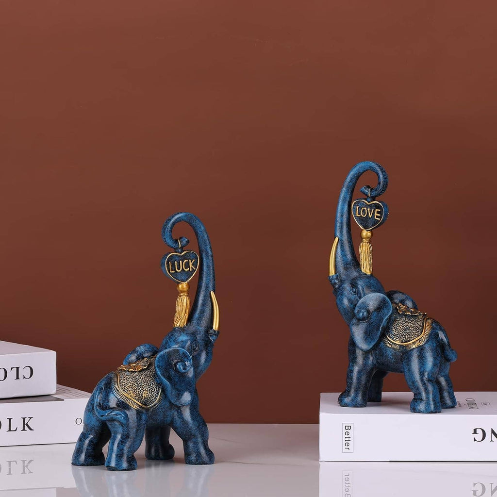 Blue elephant statues with gold trim and raised trunks, featuring “LUCK” and “LOVE” emblems