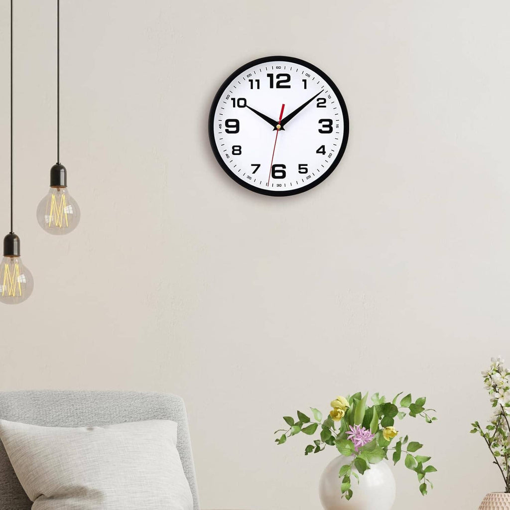 Small black analog wall clock with white dial, large numerals, red second hand