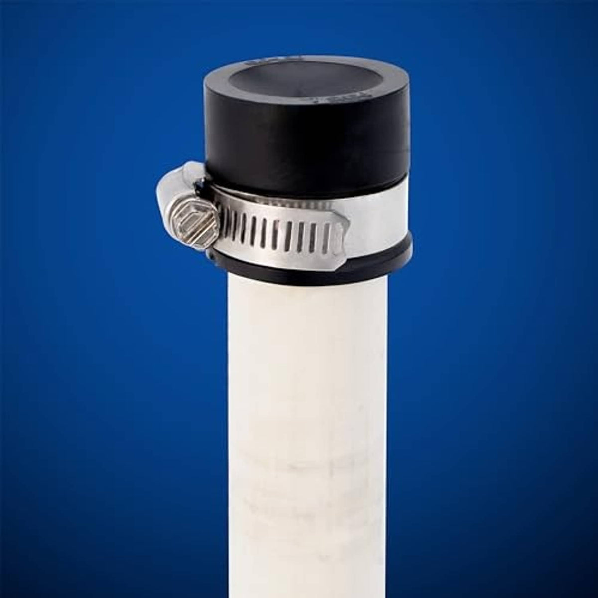 Flexible PVC pipe cap with metal clamp band and black top over white pipe