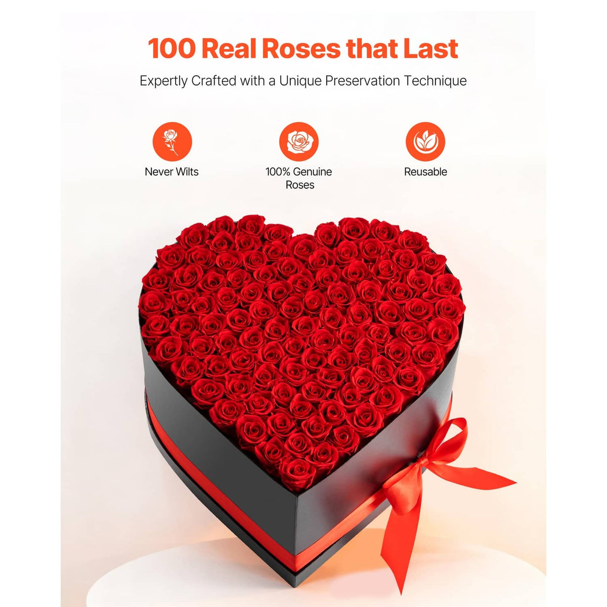 Heart-shaped black box filled with red roses, with orange-red ribbon tied on front